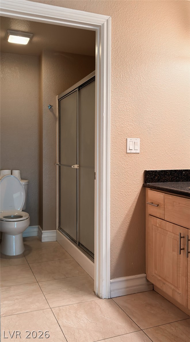 210 East Flamingo Road, Unit 112 Las Vegas, NV 89169 - Photo 15 of 59 Tiled flooring runs throughout this functional bathroom containing a walk-in shower and granite-topped vanity.
