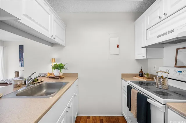 a kitchen with a sink stove and cabinets