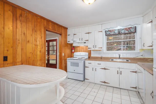 a kitchen with white cabinets and white appliances