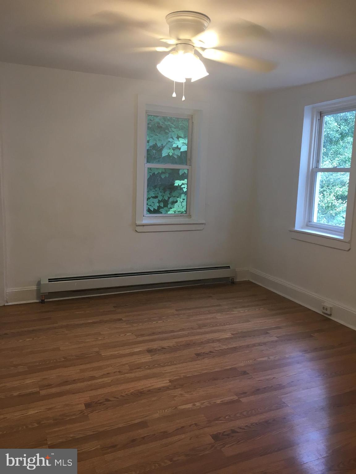 4733 Umbria Street, Unit C Philadelphia, PA 19127 - Photo 8 of 14 an empty room with wooden floor and windows