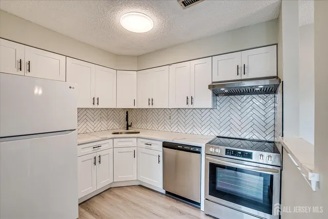 a kitchen with white cabinets and white appliances