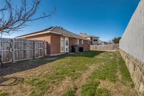 a view of a house with a small yard and wooden fence