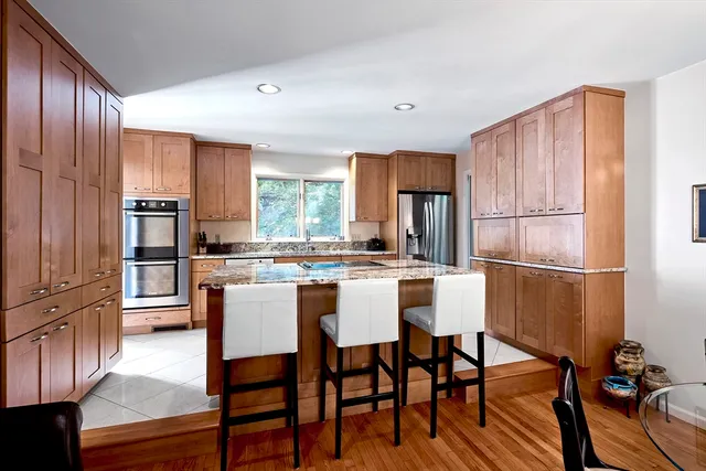 a kitchen with a table chairs refrigerator and cabinets