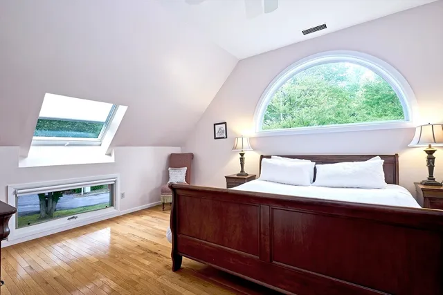 a bedroom with a bed and a wooden floor