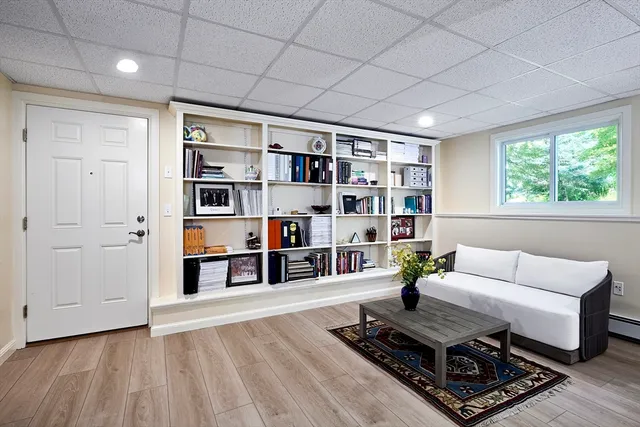 a living room with furniture hard wood floor and a book shelf