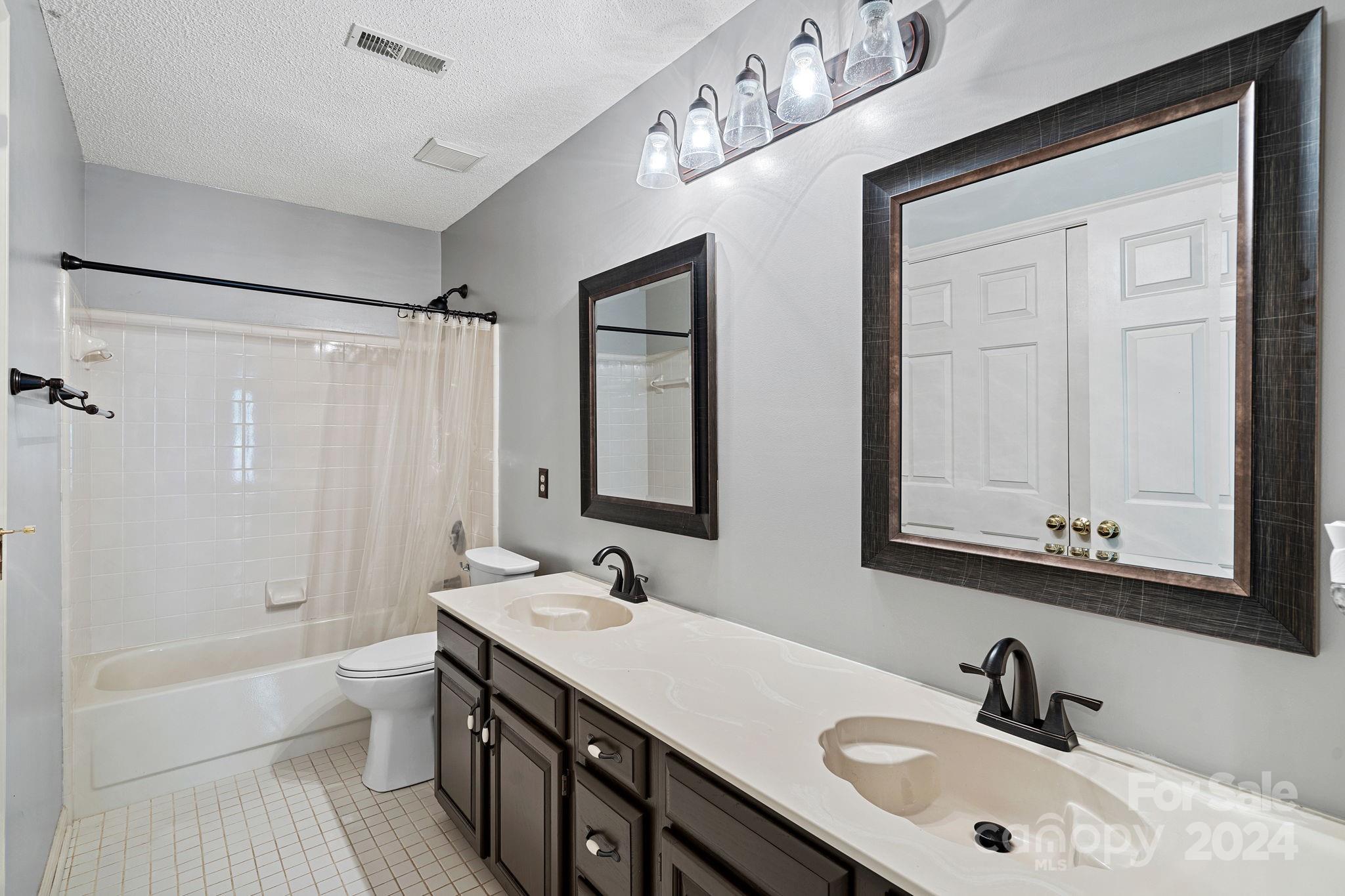12516 Hawks Ridge Road Huntersville, NC 28078 - Photo 14 of 36 a bathroom with a double vanity sink a toilet and a tub