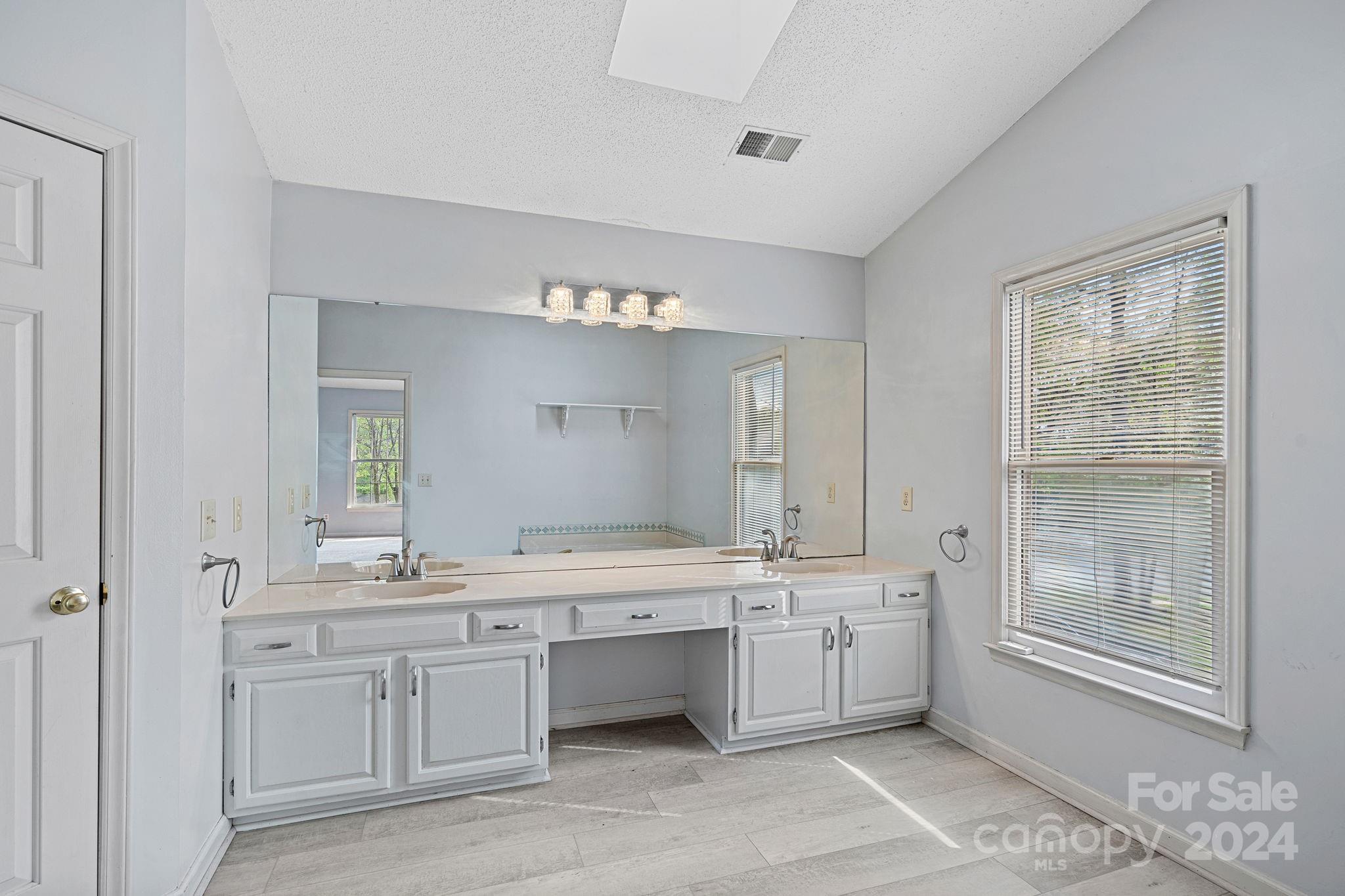 12516 Hawks Ridge Road Huntersville, NC 28078 - Photo 20 of 36 a bathroom with a double vanity sink a mirror and a bathtub