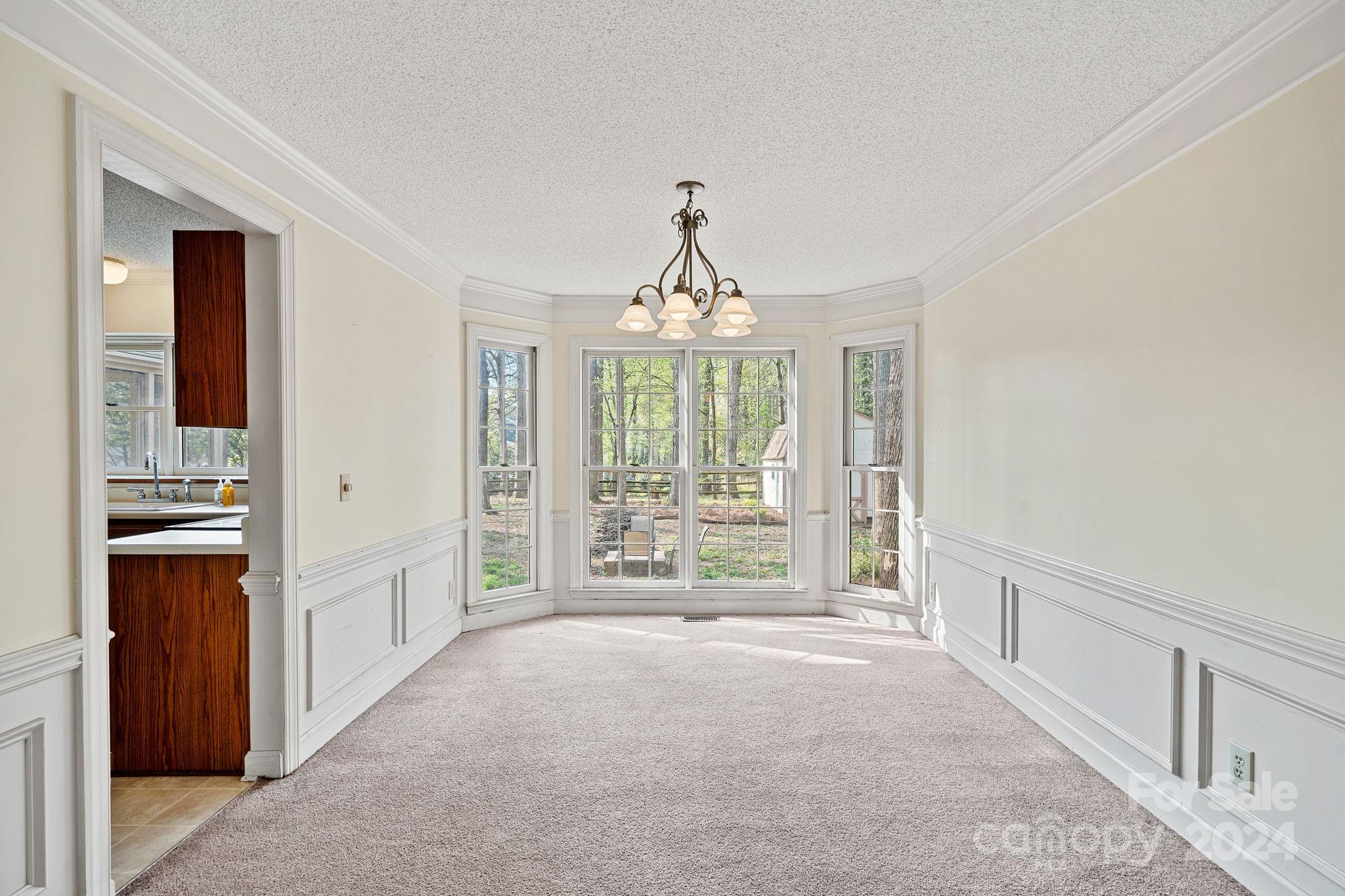 12516 Hawks Ridge Road Huntersville, NC 28078 - Photo 6 of 36 a view of an empty room with wooden floor and a window