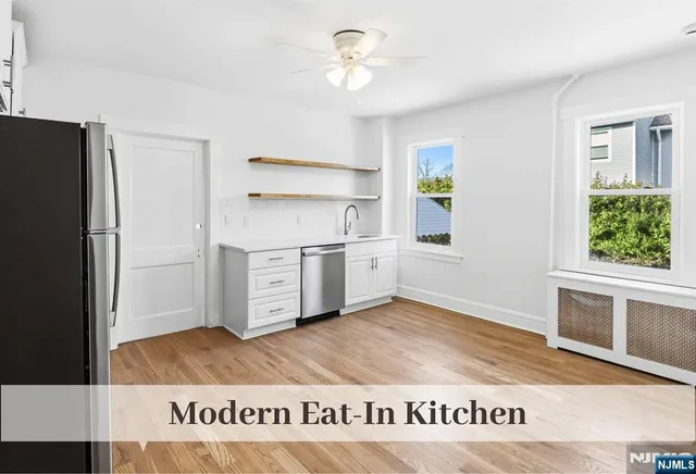a view of kitchen with stainless steel appliances granite countertop a refrigerator and a sink