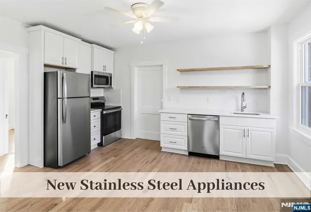 a kitchen with white cabinets and stainless steel appliances