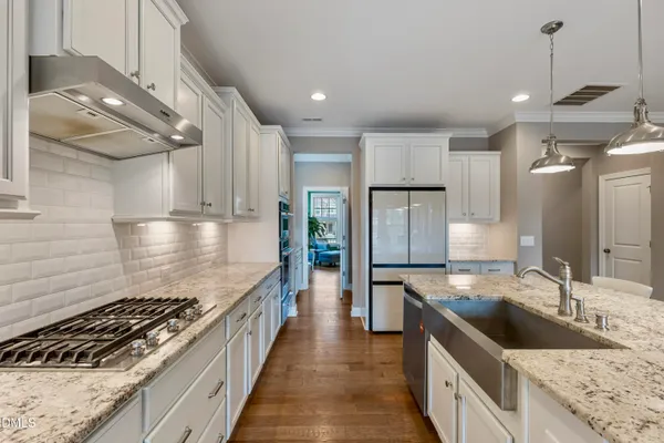 a kitchen with stainless steel appliances granite countertop a sink stove and refrigerator