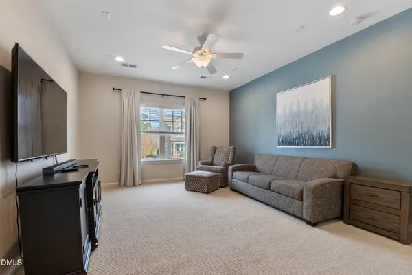 a spacious bedroom with a large bed and a chandelier