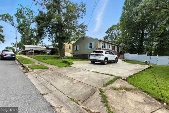 a car parked in front of a house with a small yard