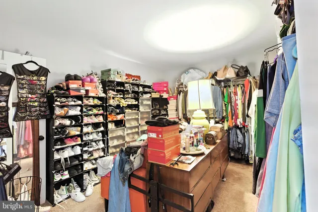 a view of walk in closet with clothes and shoes