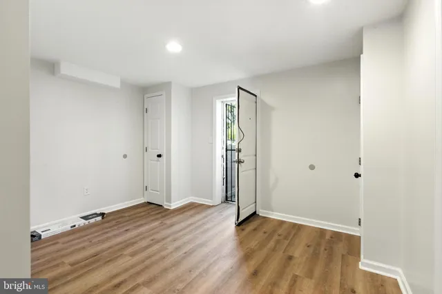 a view of empty room with wooden floor