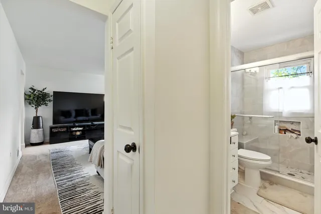 a living room with furniture a flat screen tv and a window