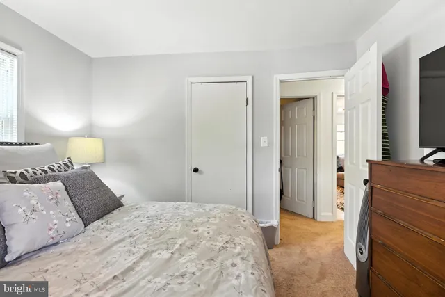 a bedroom with a bed and a flat tv screen on dresser