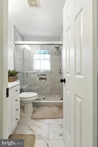 a bathroom with a toilet a sink and a window