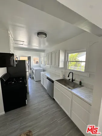 a kitchen with granite countertop a sink and cabinets