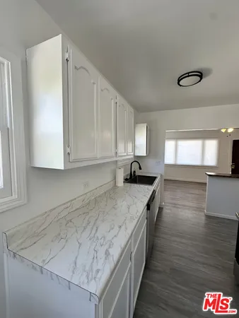 a kitchen with granite countertop a sink and a stove