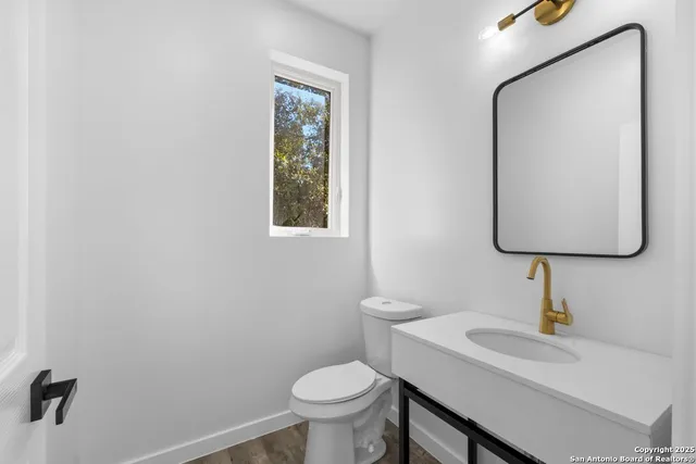 a bathroom with a toilet sink and mirror