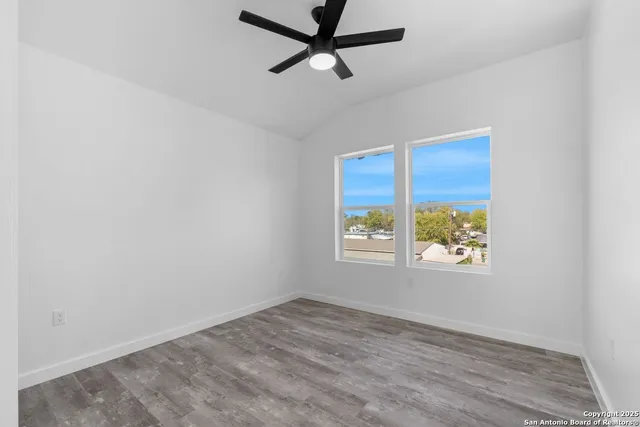 an empty room with a window and a ceiling fan