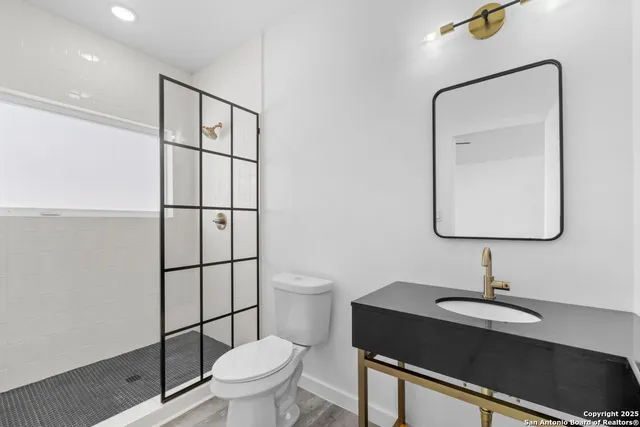 a bathroom with a toilet a sink and mirror