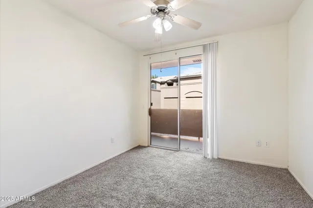 an empty room with chandelier fan and closet