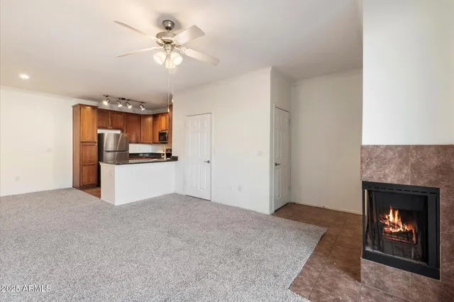 a view of a kitchen an empty room and kitchen with fireplace