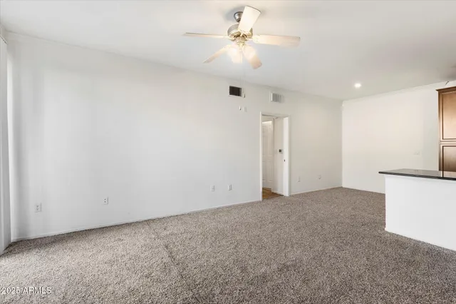 an empty room with a ceiling fan and a fan