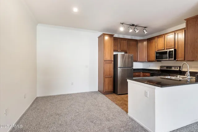 a kitchen with stainless steel appliances granite countertop a refrigerator stove a sink and dishwasher