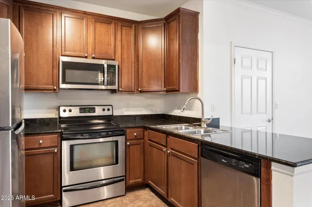 a kitchen with granite countertop wooden cabinets and stainless steel appliances