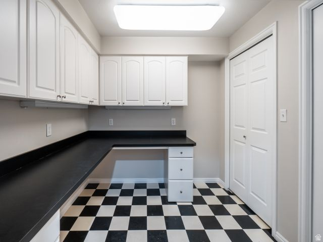 1446 West 1450 North Layton, UT 84041 - Photo 8 of 16 Utility space featuring checkerboard flooring, extensive white cabinetry, a built-in black countertop, and bi-fold closet doors