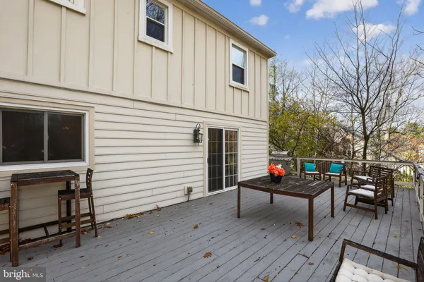 a view of a patio with couches chairs and wooden floor