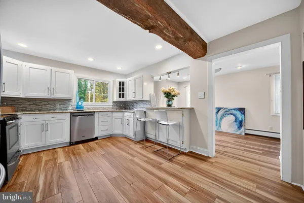 a kitchen with a refrigerator a sink dishwasher with a dining table and chairs