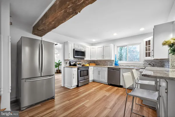 a kitchen with a refrigerator sink and white cabinets