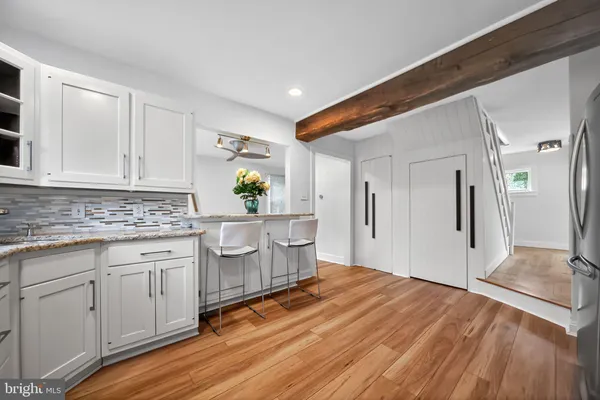 a view of a kitchen with wooden floor electronic appliances and furniture