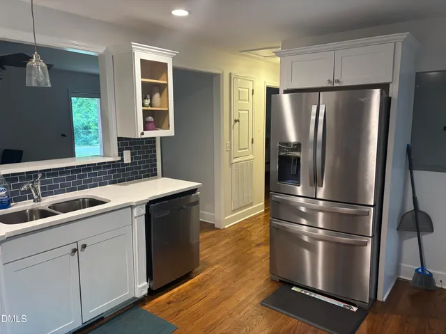 a kitchen with stainless steel appliances a refrigerator sink and cabinets