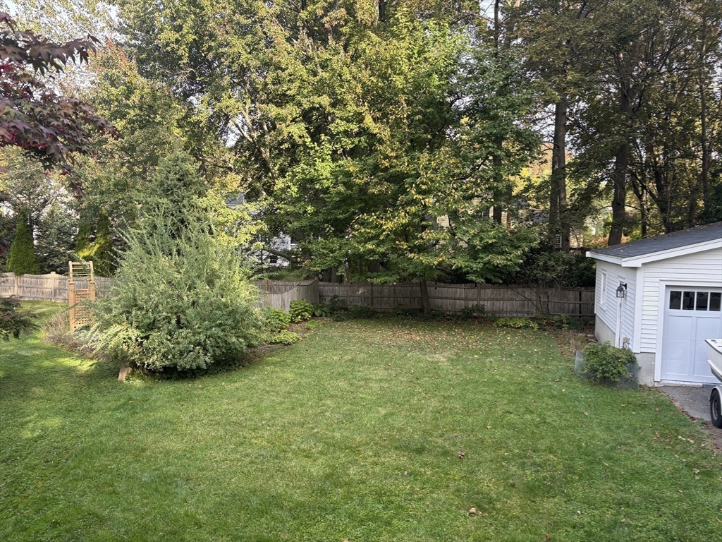 103 Oak Street Reading, MA 01867 - Photo 32 of 35 a backyard of a house with lots of plants and tree