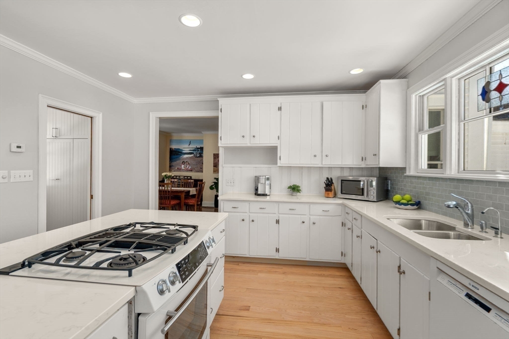 103 Oak Street Reading, MA 01867 - Photo 7 of 35 a kitchen with white cabinets and appliances