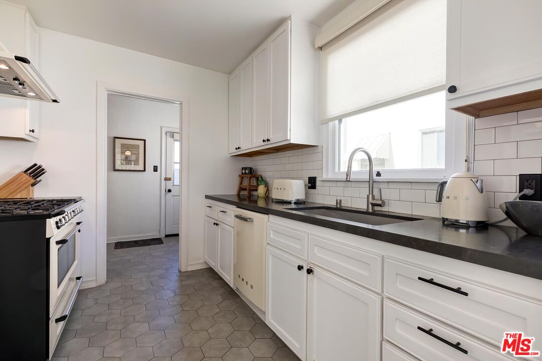 3720 Valleybrink Road Los Angeles, CA 90039 - Photo 12 of 31 a kitchen with granite countertop white cabinets and white appliances