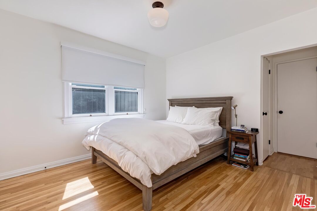 3720 Valleybrink Road Los Angeles, CA 90039 - Photo 17 of 31 a bed sitting in a bedroom next to a window and a wooden floor