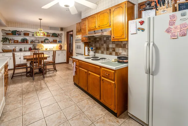 a kitchen with stainless steel appliances kitchen island granite countertop a refrigerator and a stove