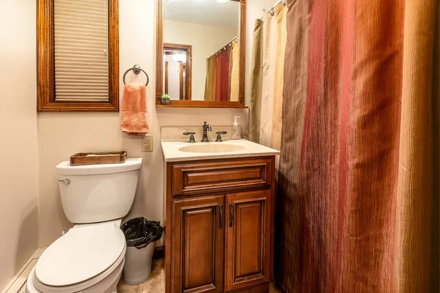 a bathroom with a toilet a sink and a mirror