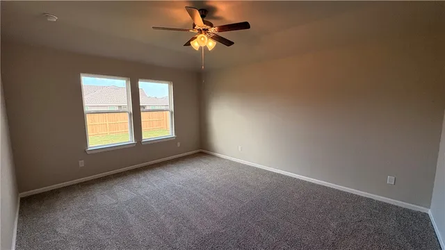 a view of an empty room with kitchen and kitchen view