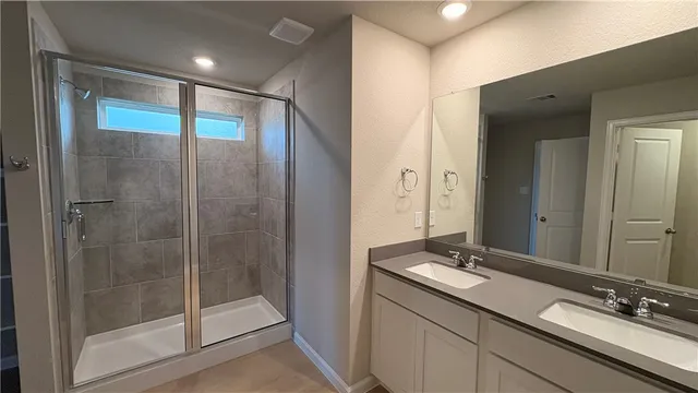 an empty room with a chandelier fan and windows