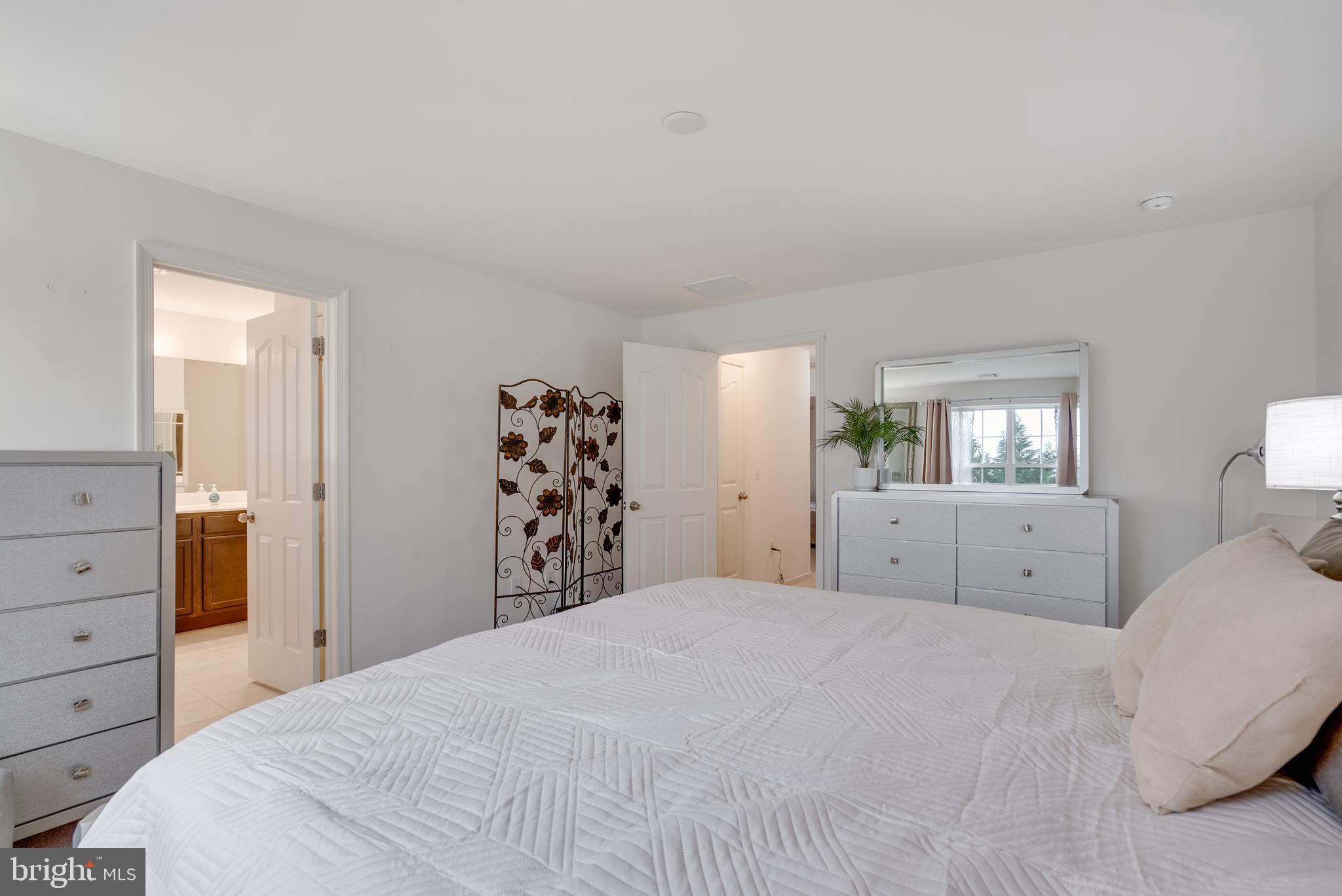 49 Creekside Way Burlington, NJ 08016 - Photo 14 of 25 a bedroom with a large bed and dresser with mirror