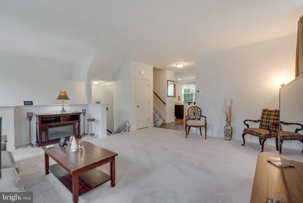 a living room with furniture a dining table and a piano with wooden floor
