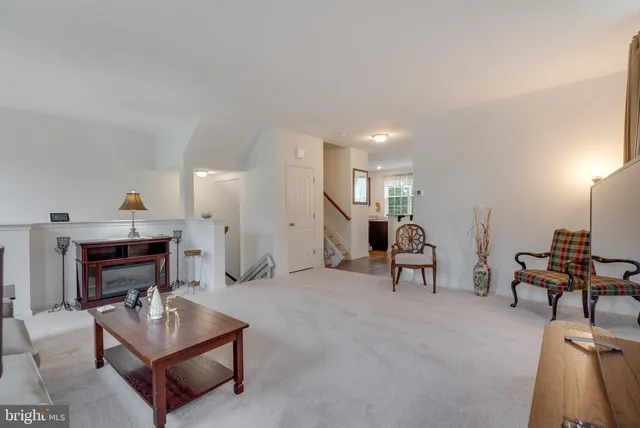 a living room with furniture a dining table and a piano with wooden floor