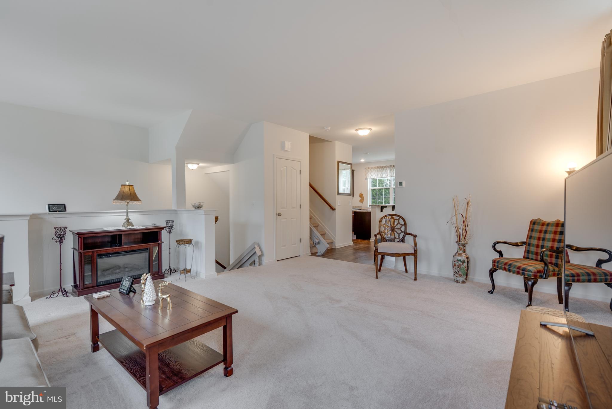 49 Creekside Way Burlington, NJ 08016 - Photo 6 of 25 a living room with furniture a dining table and a piano with wooden floor